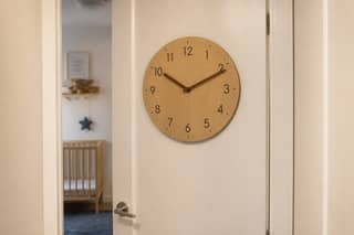 Reloj y puerta de aula en guardería, evocando horario reducido de la primera semana de septiembre