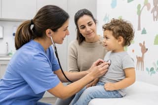 Pediatra examinando a un bebé en consulta antes de empezar la escuela infantil